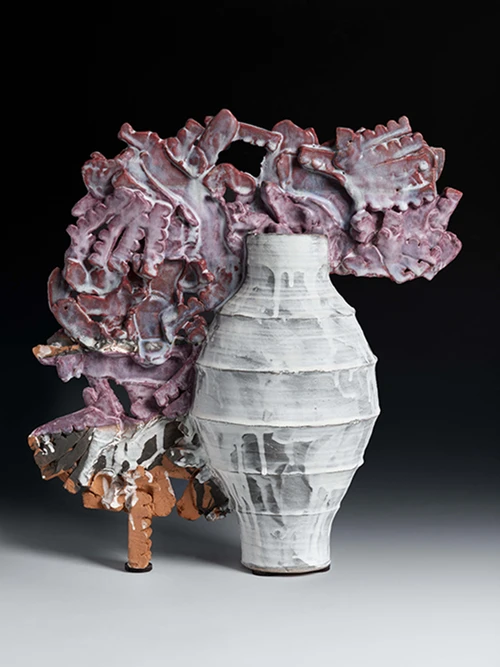 The exhibit features ceramic works such as “Red Stripes,” highlighting Wells’ exploration of form and color.